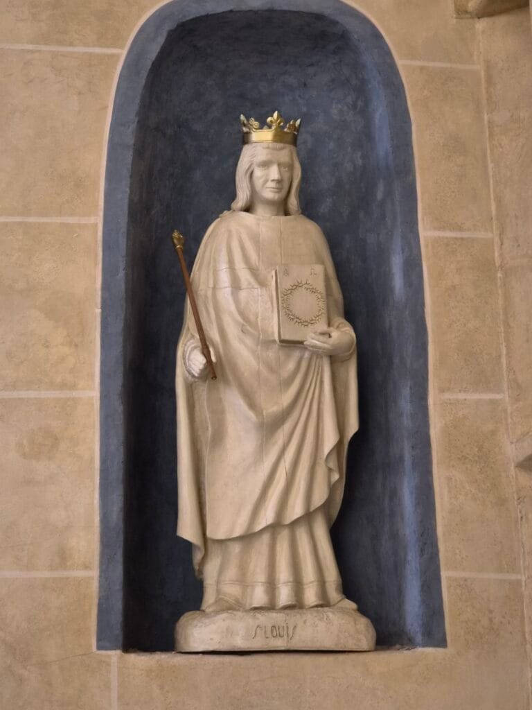 Statue de Saint Louis (roi Louis IX), couronné, tenant un sceptre et un livre, dans une niche de l'église de Saint-Gengoux